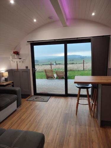 a living room with a table and a large window at Ben Aigan in Keith