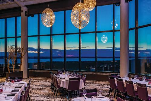 jadalnia ze stołami i krzesłami oraz dużymi oknami w obiekcie Grand Traverse Resort and Spa w mieście Traverse City
