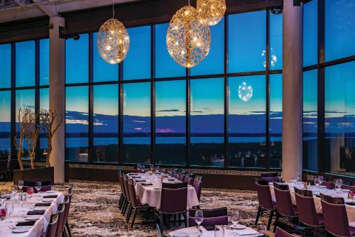 una sala da pranzo con tavoli, sedie e ampie finestre di Grand Traverse Resort and Spa a Traverse City