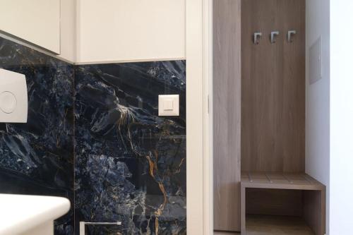 a bathroom with a black marble wall at Lake Blues in Brissago