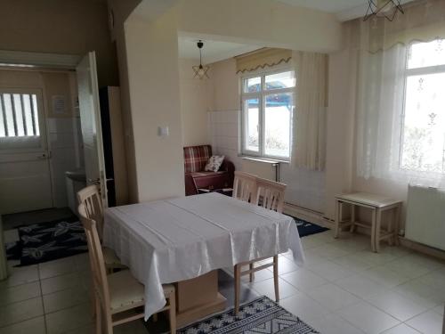 ein Esszimmer mit einem weißen Tisch und Stühlen in der Unterkunft Sakin ev Cittaslow Sea Inn in Perşembe