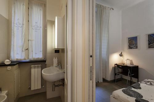 a white bathroom with a sink and a bed at A Un Passo dalla Spiaggia di Camogli by Wonderful Italy in Camogli