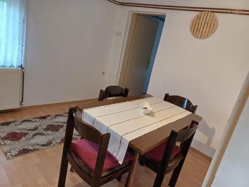 - une table à manger avec des chaises et un bol dans l'établissement Apartman DIJANA BANJA LUKA, à Banja Luka