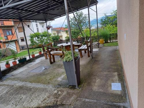 un patio avec des bancs et des tables avec un parasol dans l'établissement Apartman DIJANA BANJA LUKA, à Banja Luka