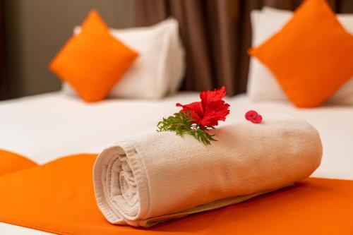 a rolled up towel with a flower on a bed at The Ridge Residence in Victoria