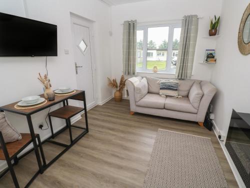 a living room with a couch and a tv at 1 Trevelyan in Helston