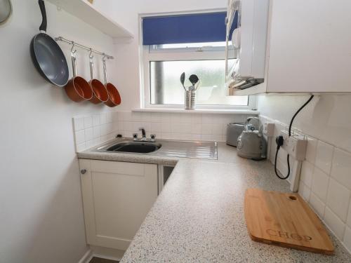 a small kitchen with a sink and a window at 1 Trevelyan in Helston