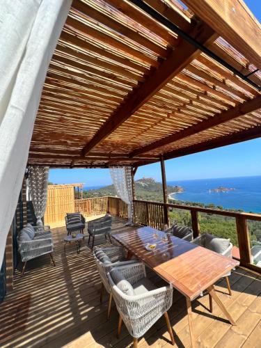 a wooden deck with a table and chairs and the ocean at Mobile Evasion okpl BEAUVOIR in Saint-Raphaël