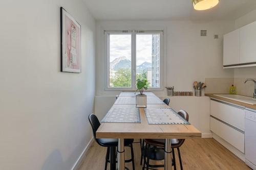 une cuisine avec une table et des chaises dans une cuisine dans l'établissement Haut standing, 4 ch dont 2 sdb privé, clim, fibre, à Grenoble
