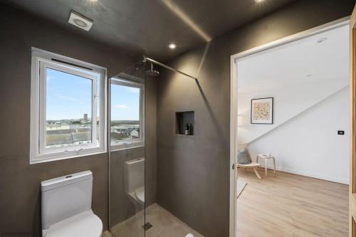 a bathroom with a toilet and a window at Stylish & Modern Home, Central Newquay w/parking in Newquay