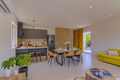 a kitchen and living room with a table and chairs at Luxury Nest Maretta & Oliva in Korčula