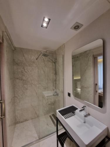 a bathroom with a shower and a sink and a mirror at Hotel Kalfa in Trabzon