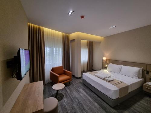 una habitación de hotel con una cama grande y una silla en Hotel Kalfa, en Trabzon