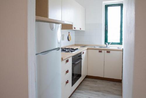 a kitchen with white cabinets and a white refrigerator at Al Frantoio Maddii Levane bed and breakfast in Levane