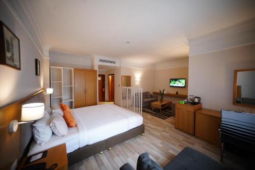 a bedroom with a large bed and a living room at Mado Hotel in Addis Ababa
