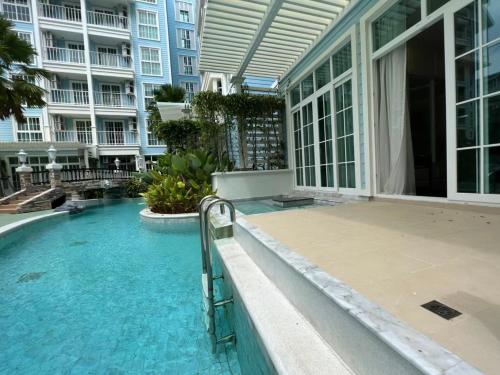 a swimming pool in front of a building at Grand Florida Holiday Home in Na Jomtien