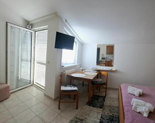 uma pequena sala de estar com uma mesa e uma cama em Studio apartman Olivera em Rovinj