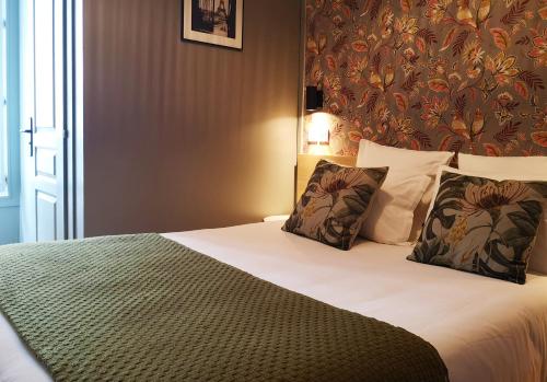 a bedroom with a large bed with two pillows at Hotel Hippodrome in Paris