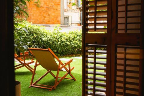 dos sillas sentadas en el césped en un patio en Fonda Hotel 1771, en Granollers