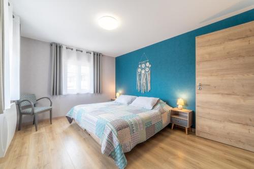 1 dormitorio con cama y pared azul en Maison Florentine, en Gunstett