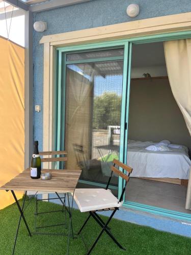 a table and chairs on a patio with a bedroom at בקתה במטע מושב אליעד in Eli Ad
