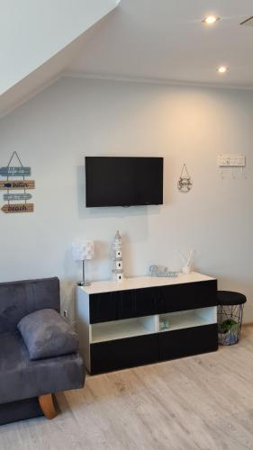 sala de estar con sofá y TV en la pared en Apartament Stegna en Stegna
