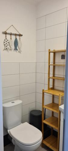a bathroom with a white toilet and a shelf at Apartament Stegna in Stegna