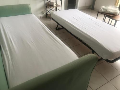une chambre d'hôpital avec deux lits et une chaise dans l'établissement Cannes studio de 24 M2 proche centre ville, au Cannet