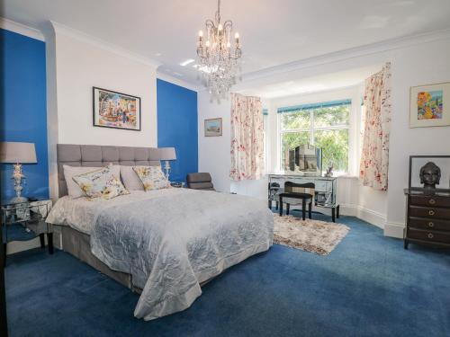 a blue bedroom with a bed and a desk at The Hideaway in Brighton & Hove
