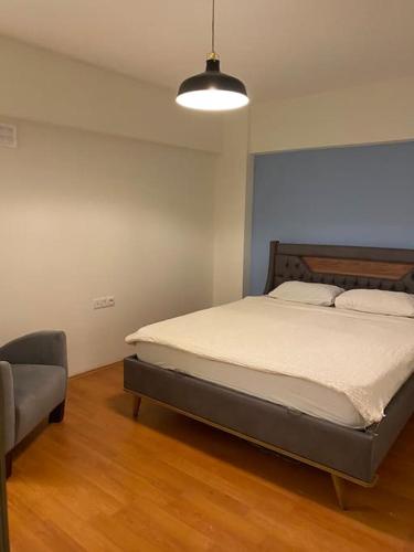 1 dormitorio con cama, silla y luz en Merkezde 2+1 Geniş Daire en Çanakkale