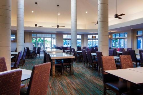 a dining room with tables and chairs and windows at Residence Inn Orlando Lake Buena Vista in Orlando