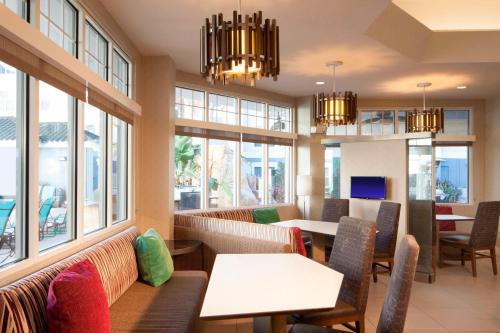 a restaurant with tables and chairs and windows at Residence Inn Orlando Lake Buena Vista in Orlando