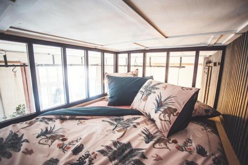 Bett in einem Zimmer mit Fenstern in der Unterkunft Stoke Fleming Studio Apartment in Stoke Fleming