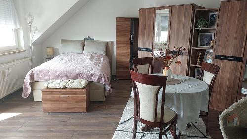 um quarto com uma cama, uma mesa e cadeiras em StayInn Möckern - 1 Zimmer Apartment für 3 Personen em Leipzig