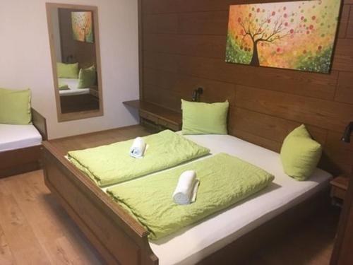 1 dormitorio con 2 camas con sábanas verdes y espejo en Aineterhof, en Ainet