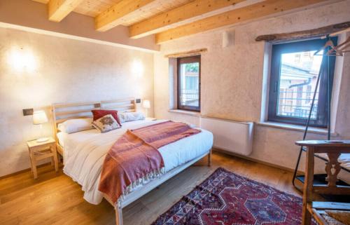 a bedroom with a bed and a large window at Le Camere di Marietta in Rovere Veronese