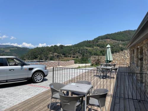 a balcony with a table and chairs and a car at Douro Cister Hotel Resort in Ucanha
