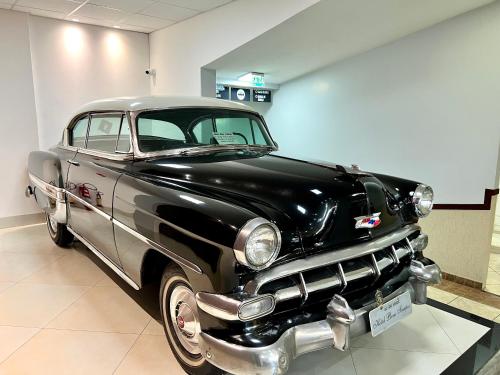 ein altes schwarzes und silbernes Auto in einem Zimmer geparkt in der Unterkunft Hotel Bons Tempos in Rio Verde
