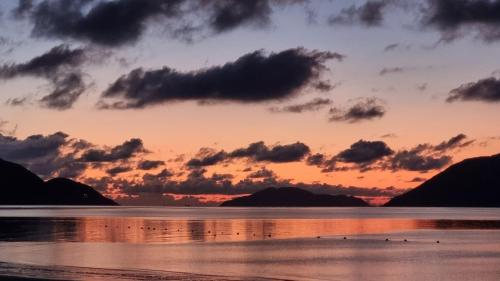 a sunset over the water with mountains in the background at Havana Con Dao Hotel in Con Dao