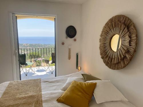 - une chambre avec un lit, un miroir et un balcon dans l'établissement Villa BaieVue, à Cavalaire-sur-Mer