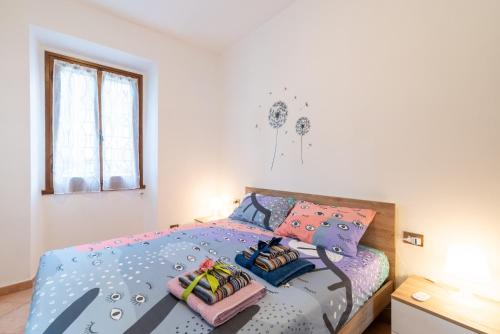 a bedroom with a bed with colorful pillows at Via del Casentino in Reggello
