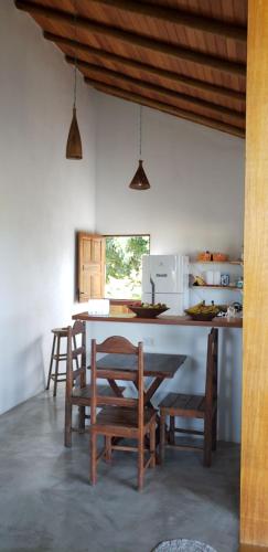 a kitchen with a table and chairs and a refrigerator at Fazenda Bom Sossego - Corumbau, BA in Corumbau