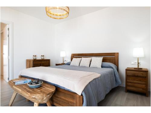 a bedroom with a large bed and a wooden table at Casa Tiare in La Oliva