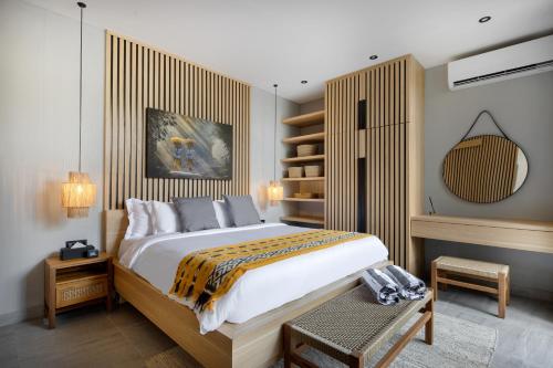 una camera con un grande letto con testiera in legno di Ananda Villa by Hombali a Jimbaran