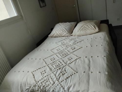 Studio Balzac في فيليوربان: سرير عليه أغطية ووسائد بيضاء