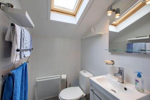 une salle de bain avec des toilettes blanches et un lavabo dans l'établissement village Khelus, à Gujan-Mestras