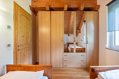 a bedroom with a wooden closet with a bed at Appartamento Davide in Pera