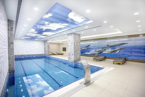 a swimming pool with a dolphin painting on the wall at Mitannia Regency Hotel in Diyarbakır