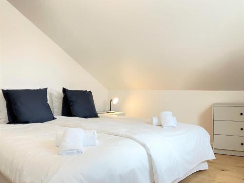 1 dormitorio con 1 cama blanca grande con almohadas azules en Furnished 2 Bedroom Apartment In Kolding, en Kolding