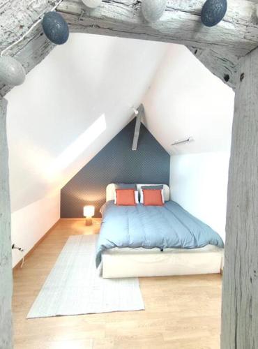 una camera da letto con letto con lenzuola blu e cuscini rossi di Da Vinci - Studio Charmant a Amboise